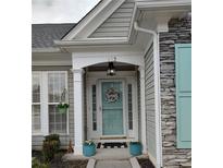 Charming home entrance with a delightful blue door, decorative wreath, and stylish stone accents at 912 Santa Anita Dr, Woodstock, GA 30189