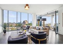 Bright living room with floor to ceiling windows and an adjacent balcony offering expansive views of the city at 3107 Peachtree Ne Rd # 1005, Atlanta, GA 30305