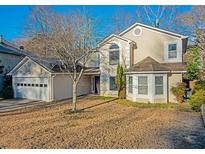 Charming two-story home features a two-car garage and mature landscaping at 8960 Terrace Club Dr, Roswell, GA 30076
