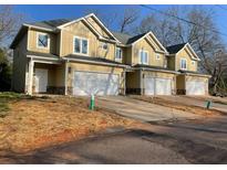 Townhomes showcase a modern exterior with neutral siding, white trim, and attached one-car garages at 6884 Robinson St, Lithonia, GA 30058