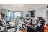 Bright living room with city views, large windows, modern furniture, and a sleek entertainment center at 2870 Pharr Court S Nw # 2006, Atlanta, GA 30305