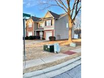 Traditional townhome showcasing a one car garage and complemented by mature landscaping at 164 Haven Oak Way, Lawrenceville, GA 30044