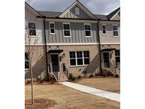 Charming two-story townhome with brick facade, gray siding, black door and small front yard at 1236 Ainsworth Aly # 37, Sugar Hill, GA 30518