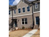 Stylish townhome exterior featuring brick facade, neutral siding, and well-maintained lawn at 1258 Ainsworth Aly # 46, Sugar Hill, GA 30518