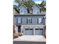 Charming townhome with gray siding, stone accents, and two-car garage at 226 Trecastle Sq # 23, Canton, GA 30114