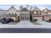 Charming townhomes featuring brick accents, neutral exteriors and two car garages at 2882 Cadence Walk Rd, Atlanta, GA 30360