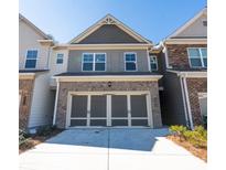 Two-story townhome featuring a brick-accented facade and a spacious two-car garage at 2882 Cadence Walk Rd, Atlanta, GA 30360