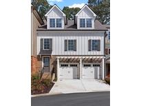 Charming exterior with white siding, brick accents, and two-car garage, creating an inviting curb appeal at 230 Trecastle Sq # 25, Canton, GA 30114