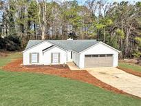 Charming one-story home with an attached garage, fresh landscaping, and a well-manicured lawn at 1666 Hearthstone Way, Jonesboro, GA 30236