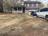 Two-story home featuring a charming front porch, two-car garage and large front yard at 869 Wytower Trl, Norcross, GA 30093