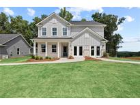 Charming two-story home featuring a well-manicured lawn and classic architectural details at 709 Mirror Lake Pkwy, Villa Rica, GA 30180