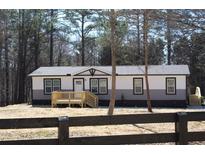 Charming single-story home with a welcoming front porch nestled among tall trees at 7382 Knox Bridge Hwy, Canton, GA 30114