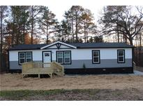 Charming home featuring black and white siding, black trim, and a cozy wooden deck at 7382 Knox Bridge Hwy, Canton, GA 30114