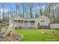 Charming single-story home with a inviting front porch and well-manicured lawn surrounded by mature trees at 437 Westmeath Sw Dr, Atlanta, GA 30310