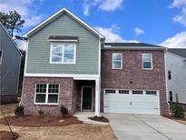 Charming two-story home featuring a brick facade and a two-car garage at 7717 Sudbury Cir, Covington, GA 30014