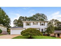 Inviting two-story home with white siding, green shutters and lush front yard at 3119 Windfield Cir, Tucker, GA 30084