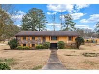 Charming one-story home with a brick and yellow-sided facade and a well-manicured front yard under a cloudy sky at 3354 Wakefield Dr, Decatur, GA 30034