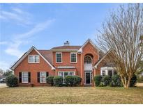Traditional brick home featuring symmetrical design, well-maintained landscaping, and a welcoming front entrance at 3069 Commons Crossing, Snellville, GA 30078