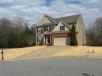 Inviting two-story home featuring brick accents, manicured lawn, and attached two-car garage at 5305 Redfield Way, Cumming, GA 30028