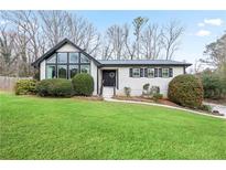 Inviting home featuring a lush, green lawn and charming curb appeal with crisp black trim at 2720 Creekview Nw Pt, Marietta, GA 30064