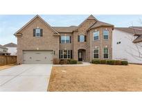 Two-story brick home features an attached garage, manicured bushes, and a well-maintained lawn at 380 Parkside Meadow Sw Dr, Marietta, GA 30064