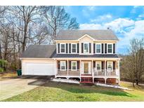 Charming two-story home featuring a welcoming front porch, attached garage and manicured lawn at 4283 Northwind Dr, Ellenwood, GA 30294