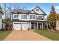 Beautiful two-story home with white siding, black trim, a two-car garage and manicured front lawn at 1010 Coleman Place Dr, Roswell, GA 30075