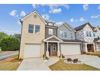 Two-story home featuring a two-car garage, complemented by a well-manicured lawn and inviting walkway at 4011 Redan Rd # 6, Stone Mountain, GA 30083