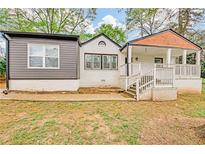 Charming home featuring a quaint covered porch, gray siding and freshly painted white brick at 2769 Glenwood Se Ave, Atlanta, GA 30317