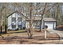 Charming two-story home with a well-maintained front yard and a single car garage at 5303 Martins Crossing Rd, Stone Mountain, GA 30088