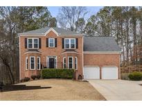 Charming two-story brick home features a two-car garage, manicured front yard and traditional architectural details at 4844 Nellrose Nw Dr, Kennesaw, GA 30152
