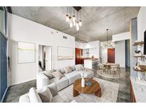 Open living room featuring a modern sofa, round wood table, and decorative lighting fixtures at 130 Arizona Ne Ave # 106, Atlanta, GA 30307