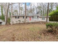 Ranch-style home features a red front door and a white porch railing at 5130 Cornwallis Ct, Stone Mountain, GA 30088