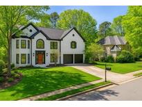 Traditional two-story home with black shutters, symmetrical windows, gabled roof, and mature landscaping at 559 Fairway Dr, Woodstock, GA 30189