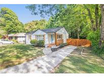 Charming home featuring a well-manicured lawn, complemented by a welcoming front porch and inviting curb appeal at 1048 Brookdale Dr, East Point, GA 30344