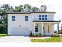 Charming two-story home featuring a covered porch, attached garage, and professionally landscaped yard at 2646 Radvell Ct, Decatur, GA 30034