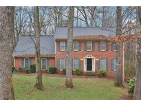 Charming brick home featuring a classic design with blue shutters and a well-manicured front yard at 3417 Starwood Sw Trl, Lilburn, GA 30047