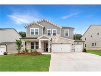 Charming two-story home featuring stone accents, a three-car garage, and well-manicured lawn at 727 Crossroad Ct, Powder Springs, GA 30127