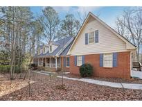 Charming brick home featuring a front porch, dormer windows, and blue shutters at 2999 Happy Hollow Dr, Conyers, GA 30094