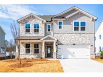 Beautiful two-story home featuring stone accents, gray shingles, and a two-car garage at 718 Crossroad Ct, Powder Springs, GA 30127