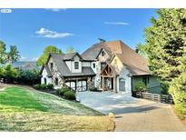 Beautiful two-story home featuring a stone facade, attached garage, and a well-manicured lawn at 3330 Chimney Point Dr, Cumming, GA 30041