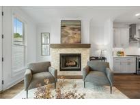 Cozy living room featuring a stone fireplace and gray armchairs at 2320 Elgar Park Pl # 95, Duluth, GA 30096