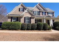 Charming brick two-story home with manicured landscaping and traditional architectural details at 283 Harmony Lake Dr, Canton, GA 30115