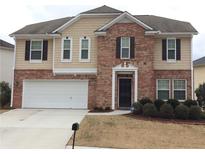 Charming two-story home featuring a brick facade, attached two-car garage, and well-manicured front yard at 2098 Cutleaf Creek Rd, Grayson, GA 30017
