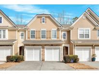 Charming townhome featuring a two-car garage and manicured landscaping at 1795 Waterside Nw Dr, Kennesaw, GA 30152