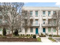 Charming townhome boasts a brick facade, inviting blue door, and well-maintained landscaping at 883 3Rd St, Alpharetta, GA 30009