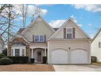 Charming two-story home featuring a stone facade, neutral siding, well-manicured landscaping, and a two-car garage at 4985 Skyland Pkwy, Cumming, GA 30028