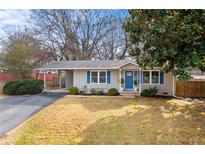 Charming single story home with blue door, blue shutters, carport and manicured front lawn at 3351 Creatwood Se Trl, Smyrna, GA 30080