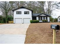 Charming two-story home with white siding, black trim, and a spacious two-car garage at 4324 Rue Saint Michel, Stone Mountain, GA 30083