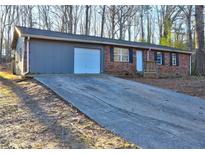 Charming single-story brick home with a driveway and garage; features black shutters and a small front porch at 5990 Mallory Rd, South Fulton, GA 30349